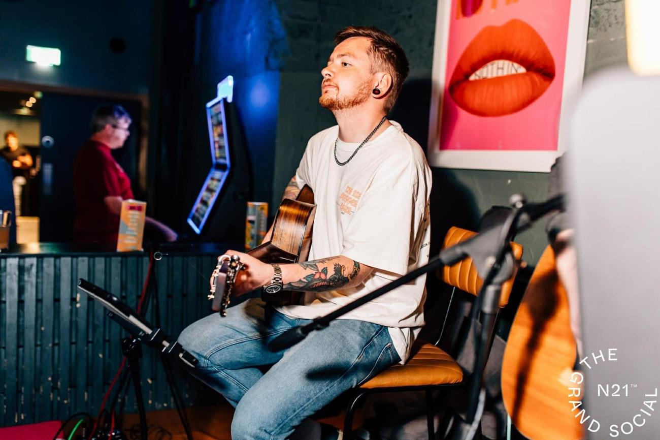 Luke Kerr playing guitar in a studio